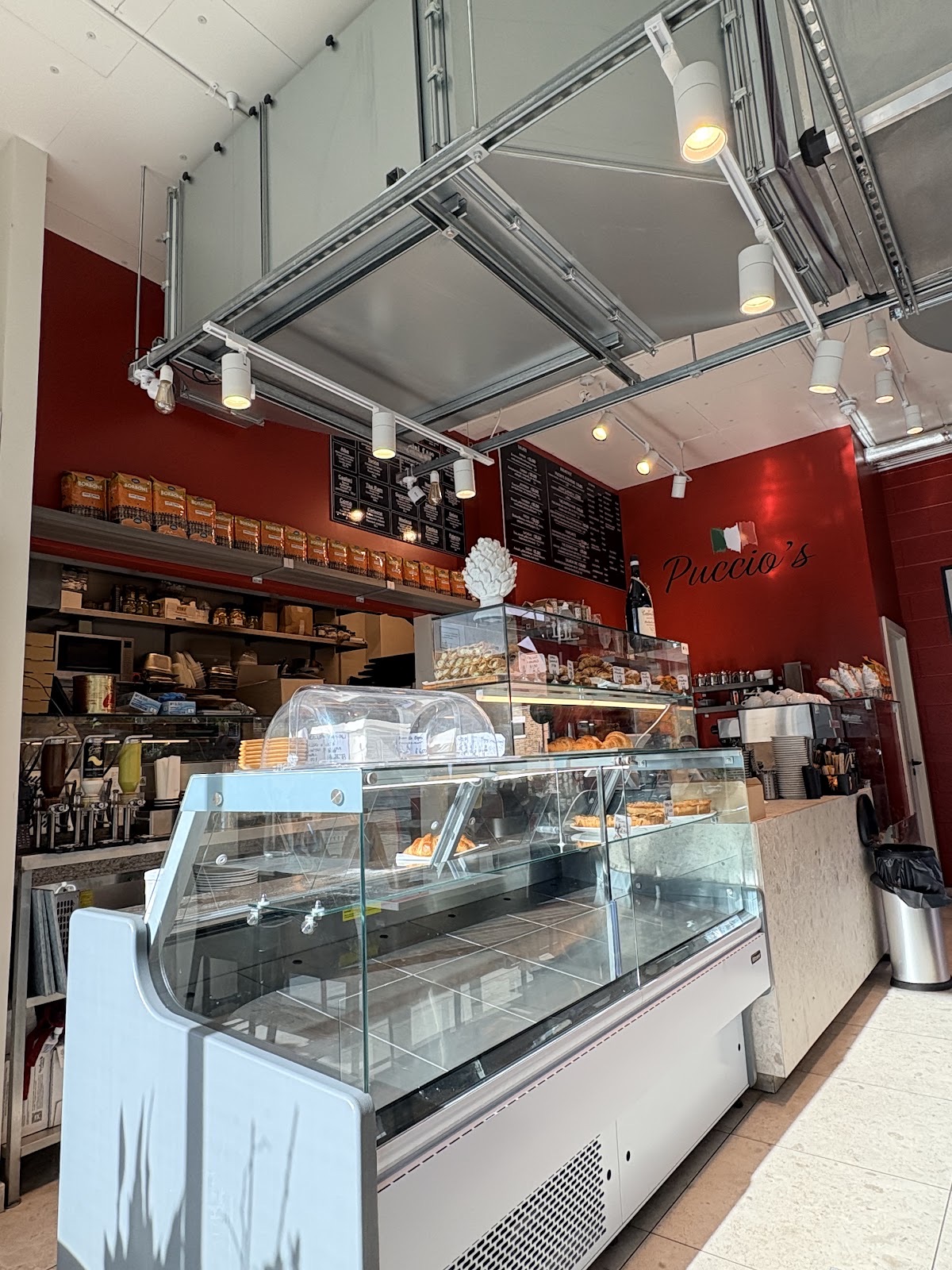 The long glass counter and shelves of Italian goods running down the shop